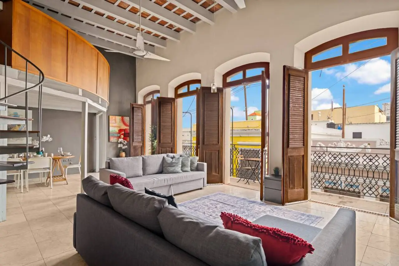 Living room with a couch and a large window — Royal Imperial | Balcony Private | Old San Juan