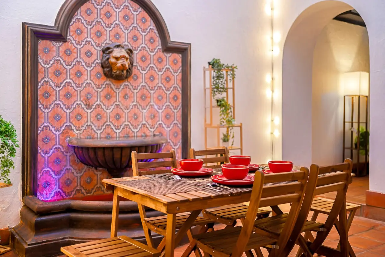 Dining table with chairs and a bowl of fruit on it — Villa Mansion - Fountain & Rooftop - Old San Juan