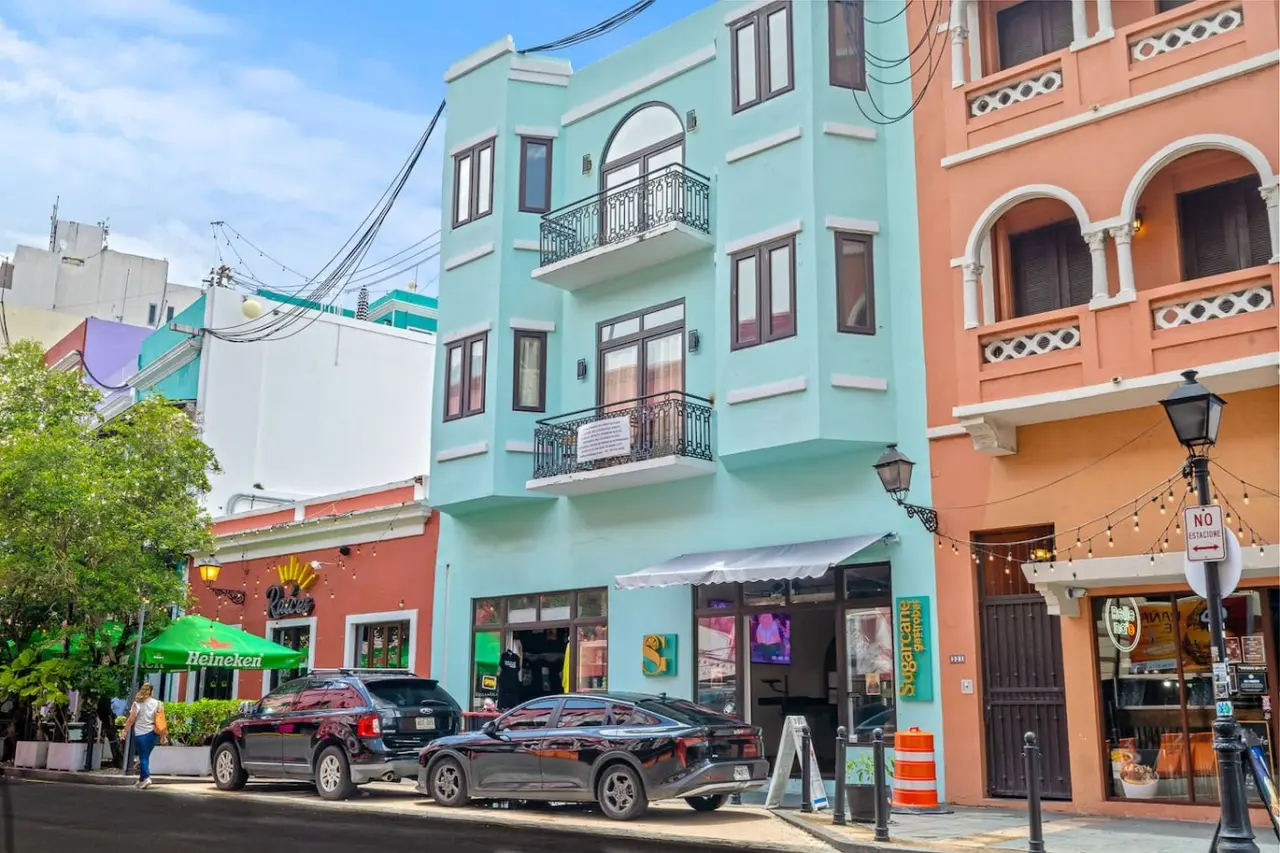 Building's turquoise facade with iron balconies — Bellavista Galleria | Old San Juan
